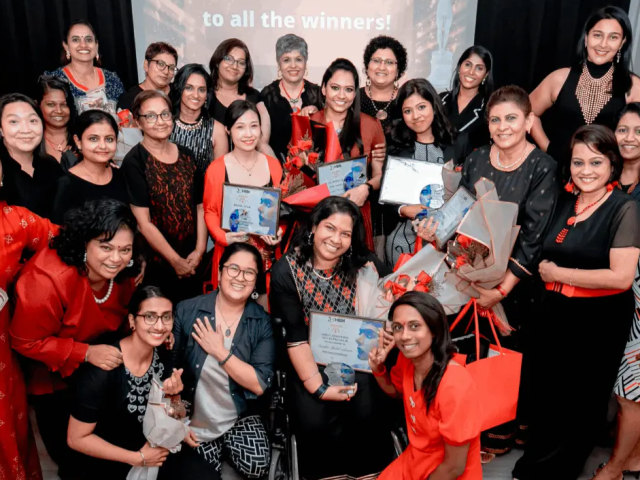 A group of happy women standing together holding certificates