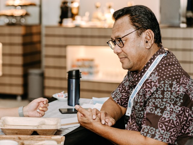 A woman and man sitting opposite each other at a table in conversation
