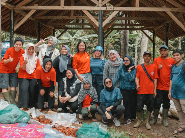 A group of IKEA co-workers and farm workers standing in front of an organic composting site on a mangosteen farm in Indonesia with social enterprise Java Fresh.