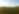 Rolling green farmlands with a bright blue sky