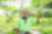 A photograph of a farmer in a green shirt proudly showing off his cucumber harvest